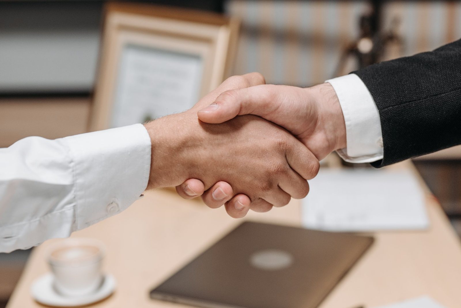 A handshake over a desk at the close of a commercial property sale.